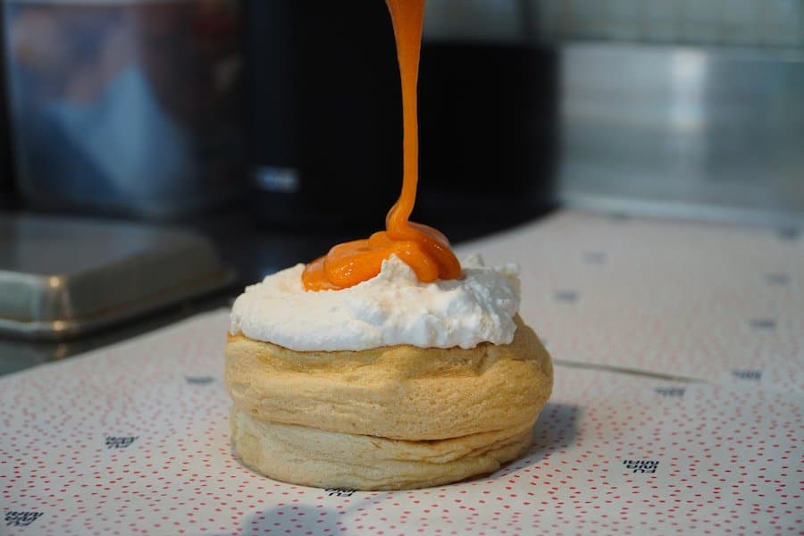 Fuwamai Japanese soufflé pancake with whipped cream being drizzled with caramel sauce at the St Julian's Malta bakery