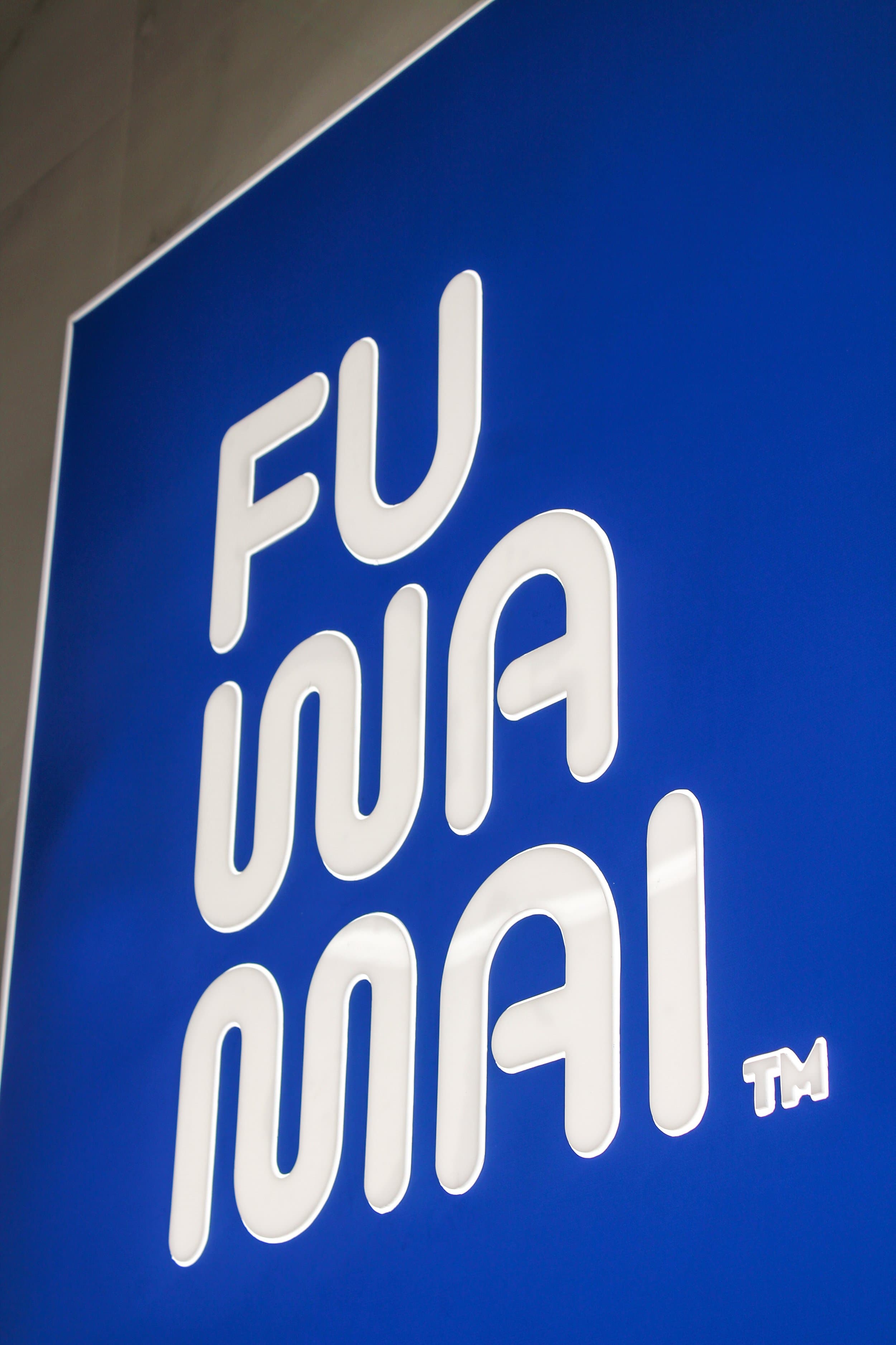 Fuwamai branded blue wall sign with raised white logo lettering at the St Julian's Malta location